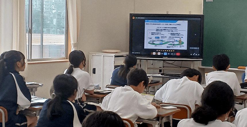 教室で児童が大型モニターを使った授業を受けている様子